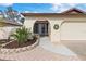 Inviting exterior with landscaped walkway leading to a covered entryway and attached garage at 616 Cherrywood Dr, Englewood, FL 34223