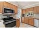 Well-equipped kitchen with stainless steel appliances and light wood cabinets at 616 Cherrywood Dr, Englewood, FL 34223