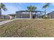 Landscaped backyard with a paved pathway leading to a screened pool and patio at 638 Andros Ct, Punta Gorda, FL 33950