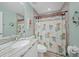 Bathroom with granite countertop, shower, and palm tree-patterned shower curtain at 7083 Mifflin St, Englewood, FL 34224