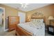 Bedroom with wooden bed frame, dresser, and ceiling fan at 7083 Mifflin St, Englewood, FL 34224