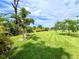 Landscaped backyard with lush green grass and tropical plants at 8117 Thruso Rd, Port Charlotte, FL 33981