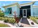 Landscaped entryway with brick walkway and teal shutters at 8117 Thruso Rd, Port Charlotte, FL 33981