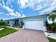 White garage door and light blue house exterior with landscaping at 8117 Thruso Rd, Port Charlotte, FL 33981