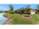 Well-manicured backyard featuring a pond and screened-in pool at 8242 Lakeside Dr, Englewood, FL 34224