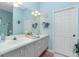 Bright bathroom with a double vanity, soft blue walls, a large mirror, and charming decor at 8242 Lakeside Dr, Englewood, FL 34224