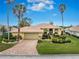 Charming yellow home featuring a well-manicured front yard, tiled roof, and brick driveway at 8242 Lakeside Dr, Englewood, FL 34224