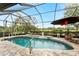 Inviting pool area featuring a covered sitting area, a golf course view, and a screened enclosure at 8242 Lakeside Dr, Englewood, FL 34224