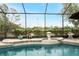 Screened-in pool featuring a charming fountain and elegant tile accents at 8242 Lakeside Dr, Englewood, FL 34224