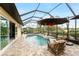 Screened-in pool with patio, decorative objects and umbrella with decorative lanterns at 8242 Lakeside Dr, Englewood, FL 34224