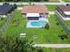 Aerial view showcasing a fenced backyard with a swimming pool, grass, and garden at 939 Silver Springs Nw Ter, Port Charlotte, FL 33948