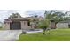 House exterior featuring a one-story home with a brown garage door and landscaped yard at 939 Silver Springs Nw Ter, Port Charlotte, FL 33948