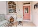 Quaint front porch with seating and a coral door at 10214 Windsong Rd, Punta Gorda, FL 33955