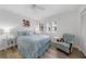 Bright bedroom with light blue bedding, hardwood floors, and an armchair at 115 Breakers Ct # 111, Punta Gorda, FL 33950