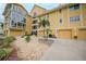 Attractive building exterior with yellow siding, garages, and landscaping at 115 Breakers Ct # 111, Punta Gorda, FL 33950