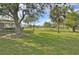 Spacious backyard with lush grass, mature trees and a partial home view at 13366 Bronze Ave, Port Charlotte, FL 33981
