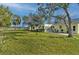 Large grassy backyard with mature trees and neighboring homes visible at 13366 Bronze Ave, Port Charlotte, FL 33981