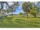 Expansive grassy backyard with mature trees and a partial home view at 13366 Bronze Ave, Port Charlotte, FL 33981