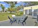 Glass-top patio table with four chairs on a concrete patio at 13366 Bronze Ave, Port Charlotte, FL 33981