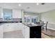 Eat-in kitchen with island, white cabinets, and view of sunroom at 13366 Bronze Ave, Port Charlotte, FL 33981