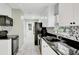 Modern kitchen with white cabinets, granite countertops, and black appliances at 13366 Bronze Ave, Port Charlotte, FL 33981