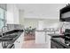 Open kitchen features white cabinets, granite counters, and breakfast bar at 13366 Bronze Ave, Port Charlotte, FL 33981