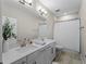 Modern bathroom boasts double vanity, large mirror, and shower/tub combo at 13742 Green Hammock Pl, Bradenton, FL 34211