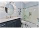 Modern bathroom with a blue vanity, walk in shower, and patterned floor at 15105 Aldama Cir, Port Charlotte, FL 33981