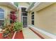 Front entry with a screened door, lush landscaping, and a walkway at 1551 Atares Dr # 112, Punta Gorda, FL 33950