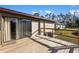 A wooden backyard deck, featuring a sliding door, and wooden railing, creating a cozy outdoor living space at 17455 Masten Ave, Port Charlotte, FL 33954