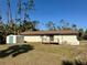 Rear view showing a light beige house with a shed and wooden deck at 17455 Masten Ave, Port Charlotte, FL 33954