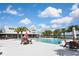 Inviting community pool with lounge chairs and patio tables under sunny skies at 17764 Palmetto Pass Ln, Punta Gorda, FL 33982