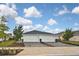 Two-car garage, light teal exterior, and landscaped yard at 17764 Palmetto Pass Ln, Punta Gorda, FL 33982