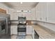 Modern kitchen with white cabinets, granite countertops and stainless steel appliances at 17764 Palmetto Pass Ln, Punta Gorda, FL 33982