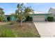 Charming light teal house with metal roof, two-car garage, and landscaped yard at 1845 Edison Dr, Englewood, FL 34224