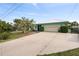 Front view of a light teal home with driveway and landscaping at 1845 Edison Dr, Englewood, FL 34224