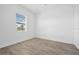 Bright bedroom featuring a window with blinds and wood-look tile floors at 19916 Bridgetown Loop, Venice, FL 34293