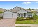 Two-story house with gray siding, a three-car garage, and landscaping at 19916 Bridgetown Loop, Venice, FL 34293