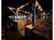 Evening view of outdoor kitchen and pergola with lights at 2474 Como St, Port Charlotte, FL 33948