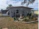 Gray house exterior with a landscaped backyard and patio area at 2488 Warne St, Port Charlotte, FL 33952