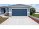 Two-car garage with blue doors and a long driveway at 27 Meadowlark Ln, Placida, FL 33946