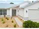 Front view of house showcasing gray door and garage at 28434 Sabal Palm Dr, Punta Gorda, FL 33982