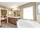 Double vanity bathroom with a large soaking tub and views into the bedroom at 3112 Club Dr # 124, Port Charlotte, FL 33953