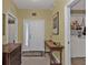 Inviting entryway with tile flooring, console table, and access to laundry room at 3112 Club Dr # 124, Port Charlotte, FL 33953