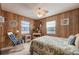 Bedroom with wood paneling, ceiling fan, and rocking chair at 3461 Normandy Dr, Port Charlotte, FL 33952