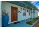 Dark wood front door with blue planter at 3461 Normandy Dr, Port Charlotte, FL 33952