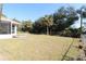 Spacious backyard with grassy area, screened patio, and mature trees at 4330 Shappell St, Port Charlotte, FL 33948
