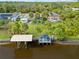 Aerial view showing home, dock, canal, and lush landscaping at 472 Eppinger Dr, Port Charlotte, FL 33953