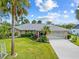 Single-story home with a gray tile roof, landscaped yard, and two-car garage at 472 Eppinger Dr, Port Charlotte, FL 33953