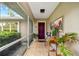 Covered front porch with tiled floor, purple door, and decorative artwork at 472 Eppinger Dr, Port Charlotte, FL 33953